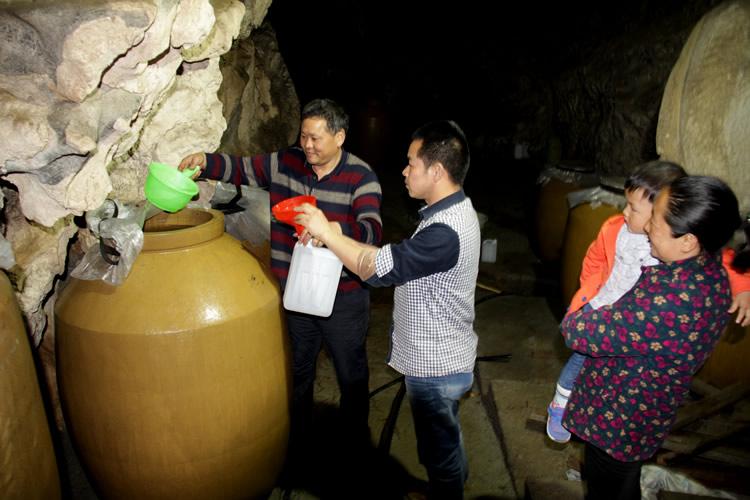 月28日,在鹤峰县盈河源专业合作社洞藏酒厂内,顾客正在购买盈河源白酒
